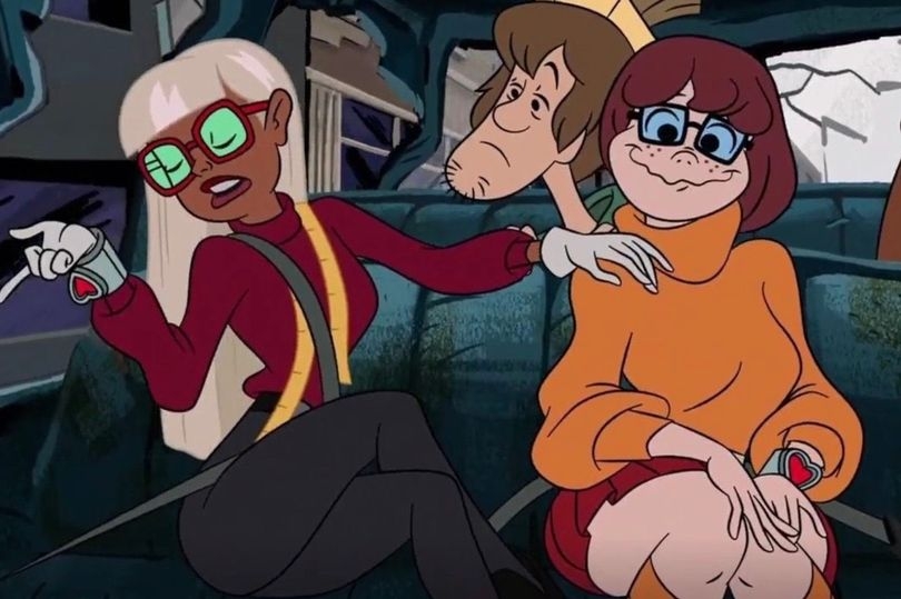 Velma Dinkely in her classic orange turtleneck interacting with her new female crush