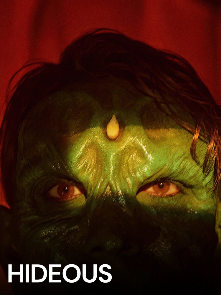 HIDEOUS: A green ogre-like face stares into the camera